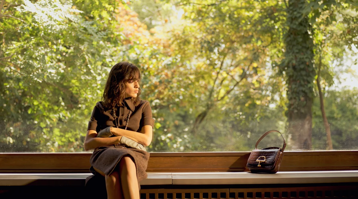 Model seated by the window with a Gucci Horsebit bag, frame from the fashion film for MOJEH
